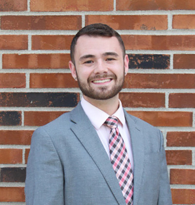 Cameron Parke, Chief Executive Officer of ZiggyZooms, standing in front of a brick wall.